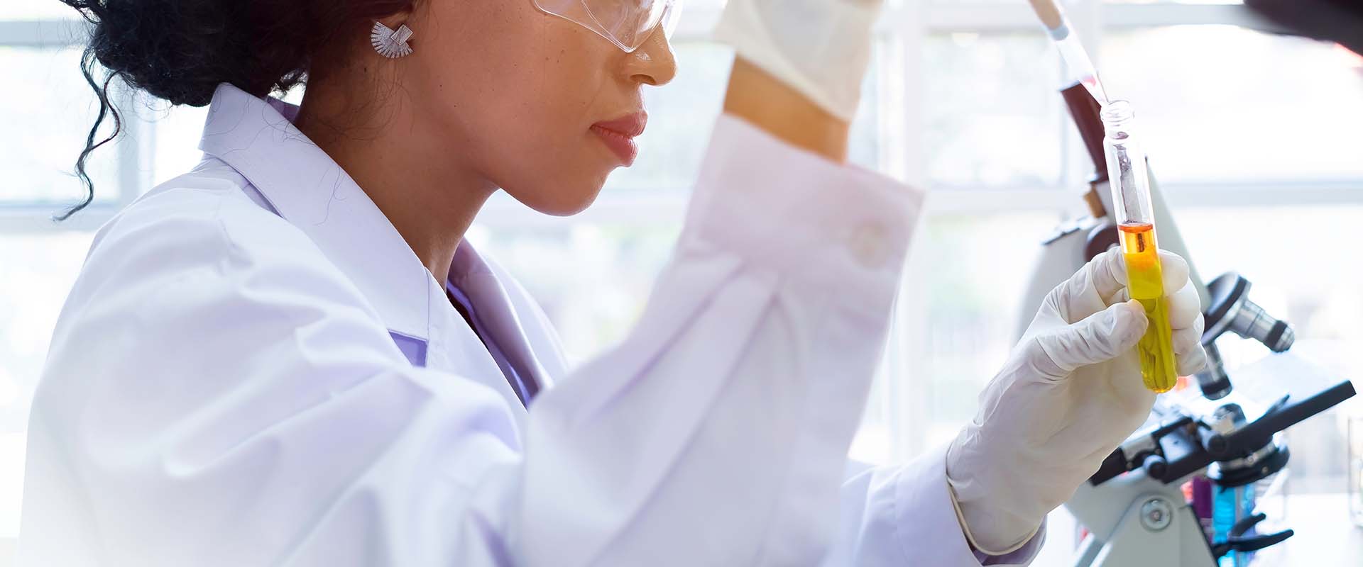 Black woman scientist looking at test tube